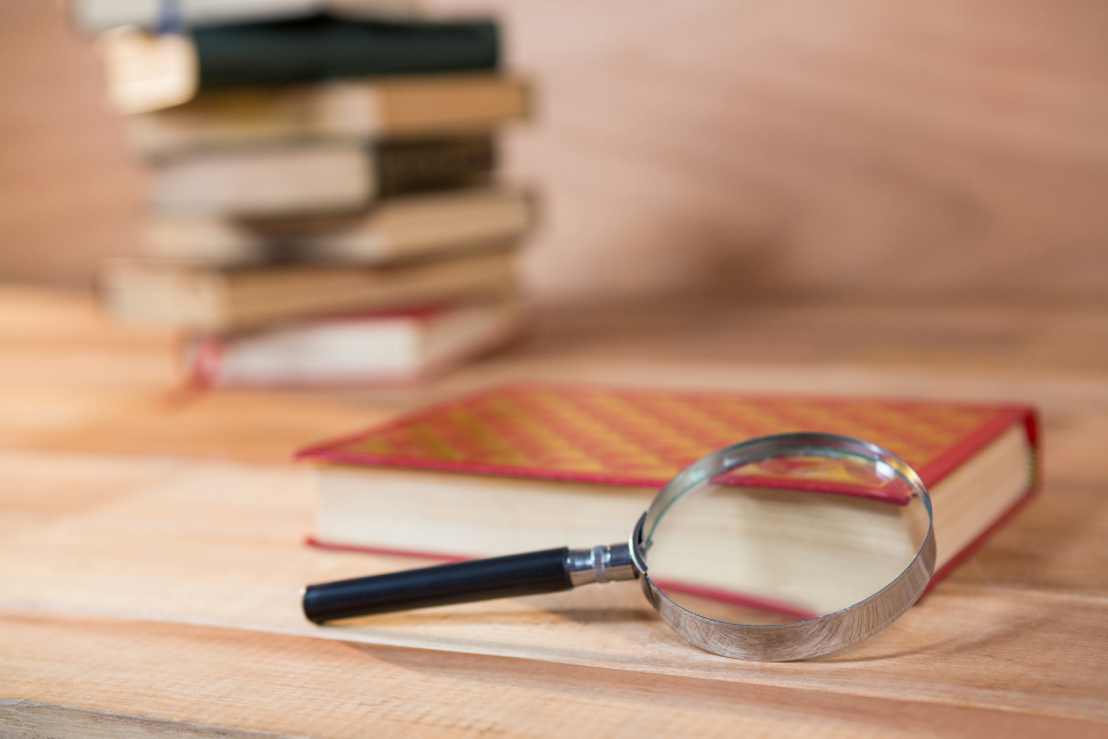 Lupa y libros para una investigación