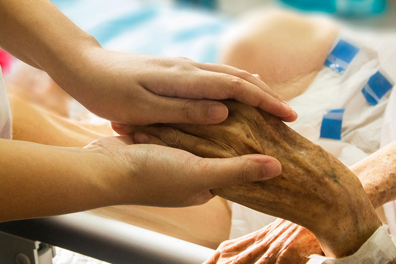 Persona sosteniendo la mano de paciente. Persona sosteniendo la mano de paciente.