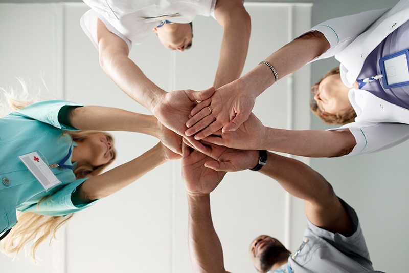 Equipo de salud multidisciplinario tomados de la mano