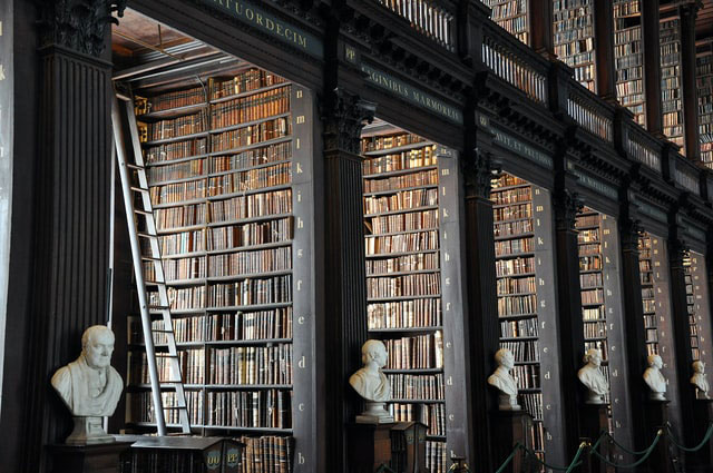 Biblioteca que muestra muchos anaqueles que llegan hasta la parte superior del primer piso