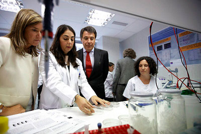 personas en un laboratorio que observan la manipulación de cierto instrumental por parte de una de ellas.