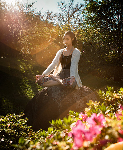Mujer sentada en el bosque, meditando.