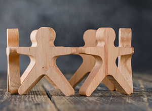 Figuras de madera en forma de personas unidas en círculo. Figuras de madera en forma de personas unidas en círculo.
