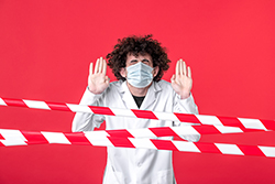 Hombre en uniforme médico con cinta de aislamiento.