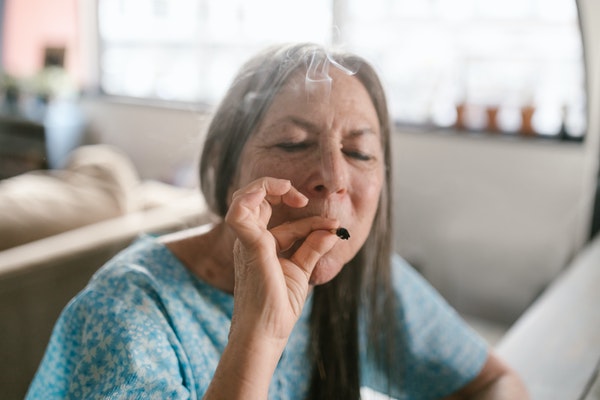 mujer con bata fumando marihuana